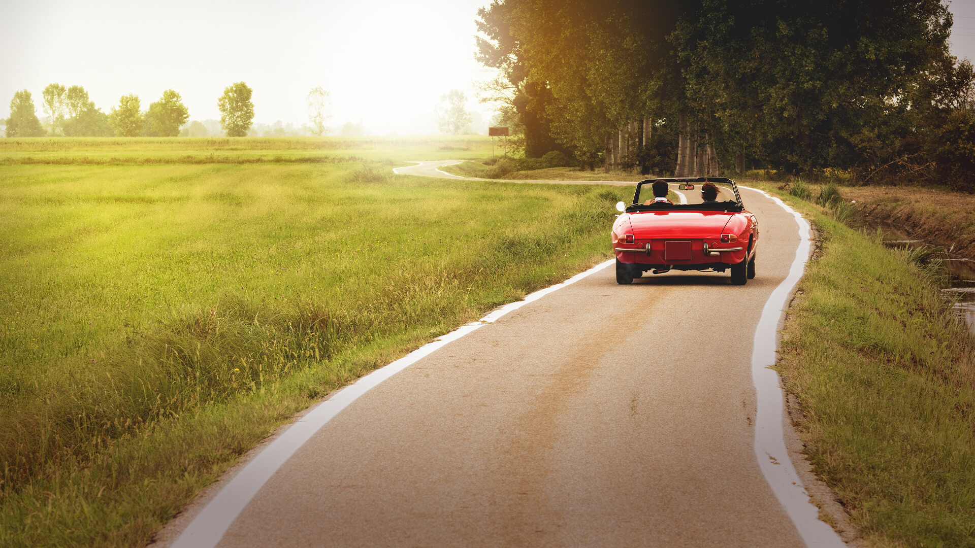 红色软顶跑车风格的汽车驾驶通过农村