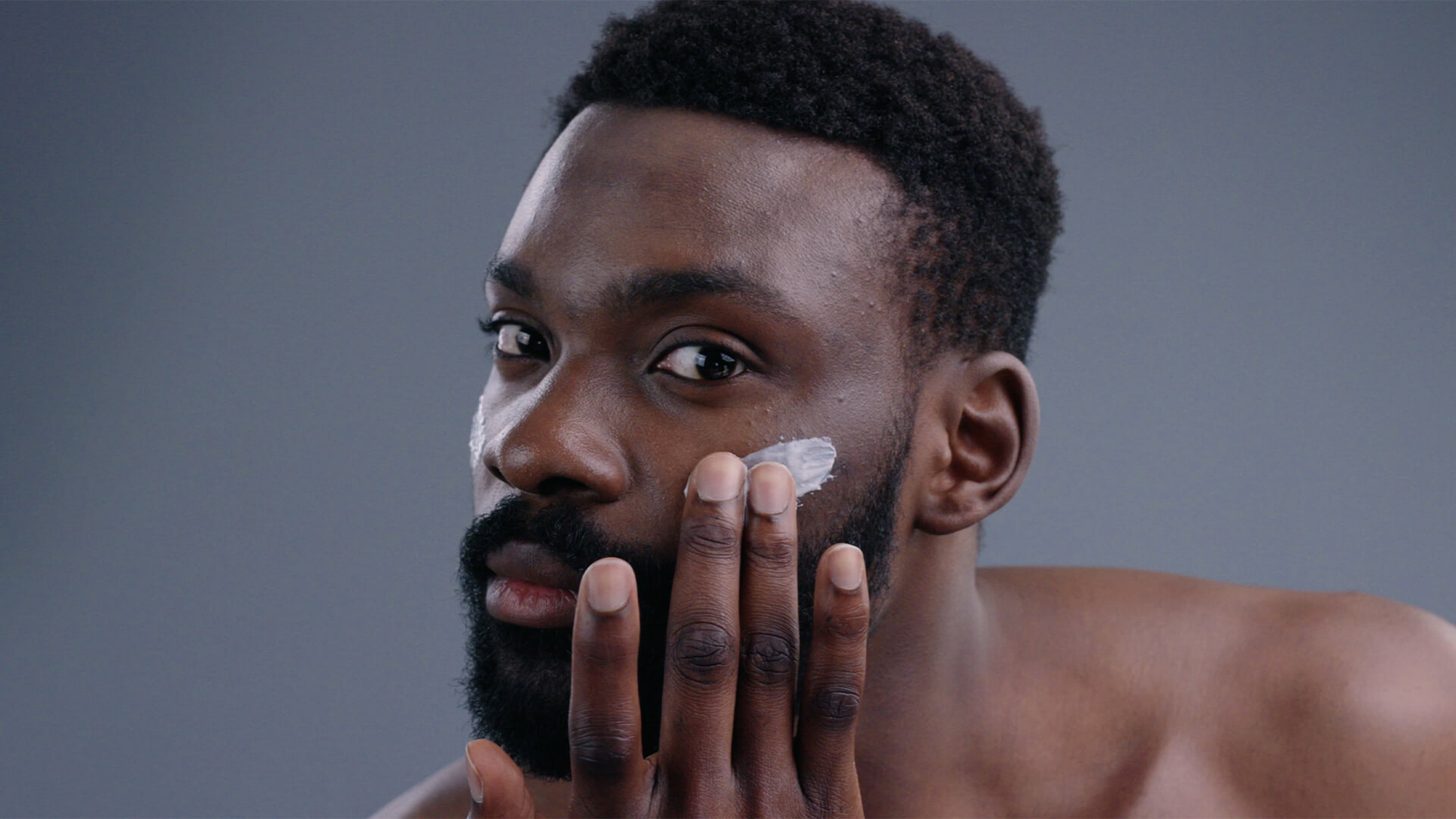 Man applying moisteriser to his face